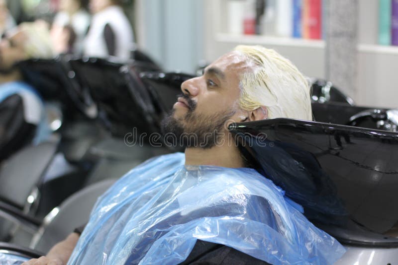 Mens die zijn haar bij een salon sterven stock fotografie Mens die zijn haar bij een salon sterven stock fotografie