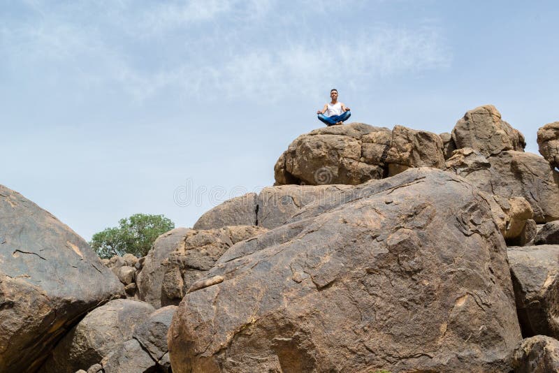 Mens in diepe yogaconcentratie op een rotsachtige berg - landschap stock afbeelding Mens in diepe yogaconcentratie op een rotsachtige berg - landschap stock afbeelding