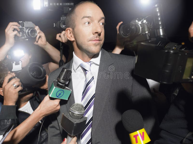 Mens door Paparazzi wordt omringd die royalty-vrije stock afbeelding Mens door Paparazzi wordt omringd die royalty-vrije stock afbeelding
