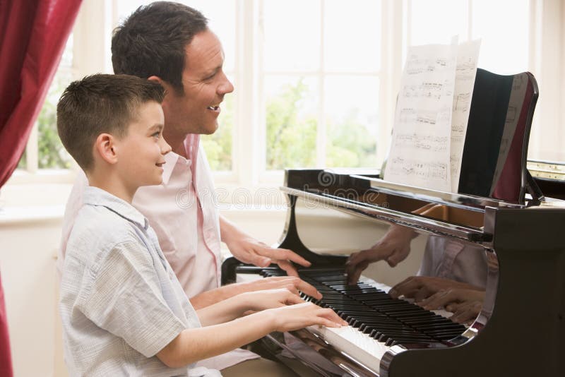 Mens en jonge jongen het spelen piano en het glimlachen
