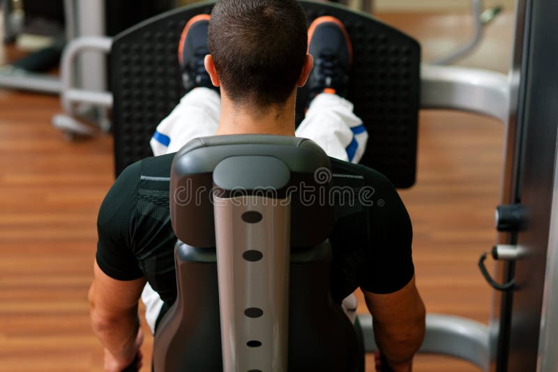 Mens in gymnastiek bij machine het uitoefenen royalty-vrije stock afbeeldingen Mens in gymnastiek bij machine het uitoefenen royalty-vrije stock afbeeldingen