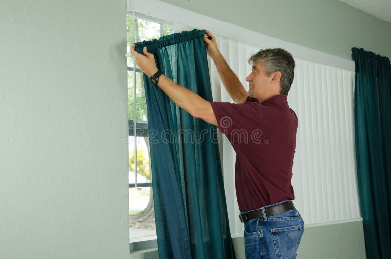 Mens het hangen de reparatieonderhoud van het gordijnenhuis royalty-vrije stock afbeelding Mens het hangen de reparatieonderhoud van het gordijnenhuis royalty-vrije stock afbeelding