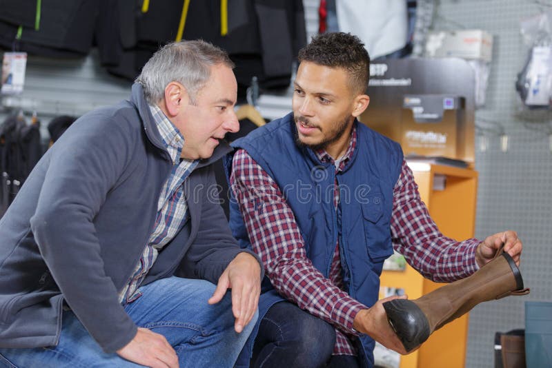 Mens het kopen berglaarzen stock fotografie Mens het kopen berglaarzen stock fotografie
