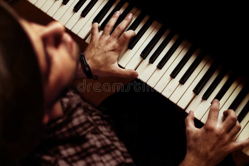 Mens het spelen op piano op dramatisch donker stadium royalty-vrije stock afbeeldingen Mens het spelen op piano op dramatisch donker stadium royalty-vrije stock afbeeldingen