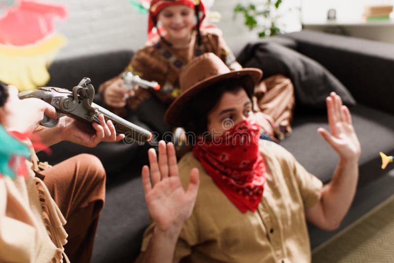 mens in hoed en het rode bandana spelen samen met zonen in inheemse kostuums stock fotografie mens in hoed en het rode bandana spelen samen met zonen in inheemse kostuums stock fotografie