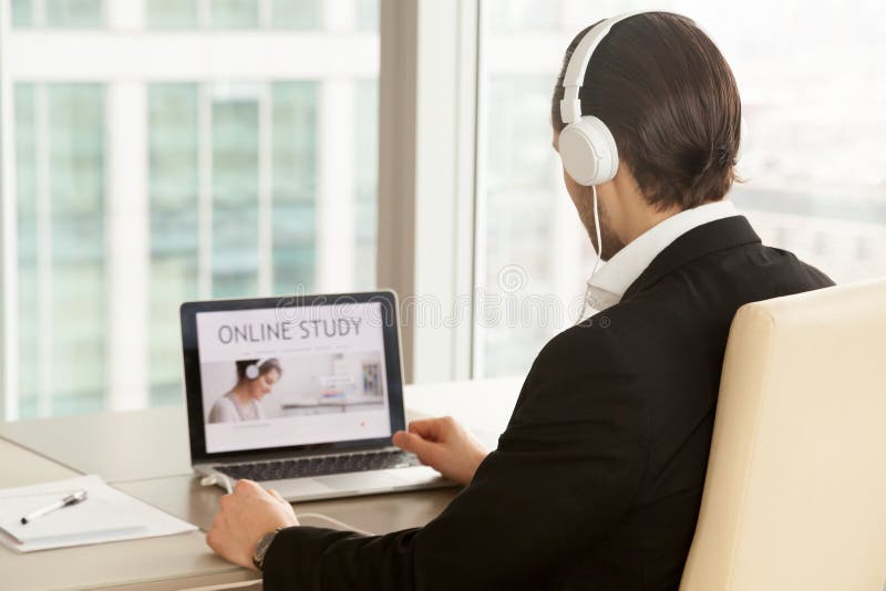 Mens in hoofdtelefoons die online cursus gebruiken stock foto Mens in hoofdtelefoons die online cursus gebruiken stock foto