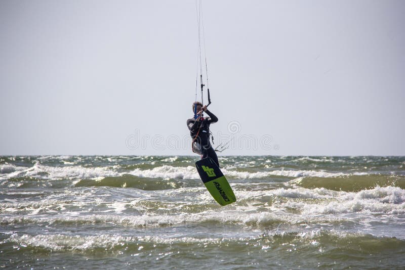 Mens Kiteboarding en het Springen op een Vliegerraad stock afbeeldingen Mens Kiteboarding en het Springen op een Vliegerraad stock afbeeldingen