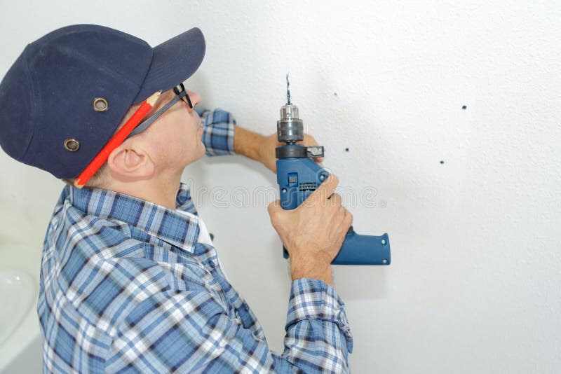 Mens klaar om muur met perforator te boren royalty-vrije stock foto Mens klaar om muur met perforator te boren royalty-vrije stock foto
