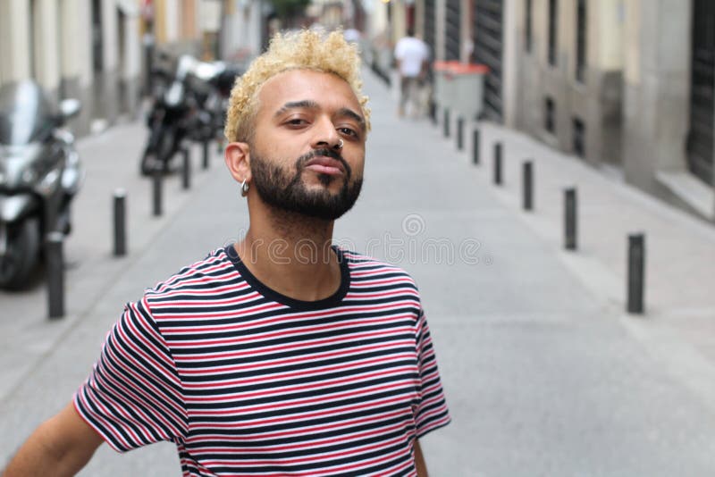 Mens met blond geverft afrohaar die in openlucht stellen stock foto's Mens met blond geverft afrohaar die in openlucht stellen stock foto's