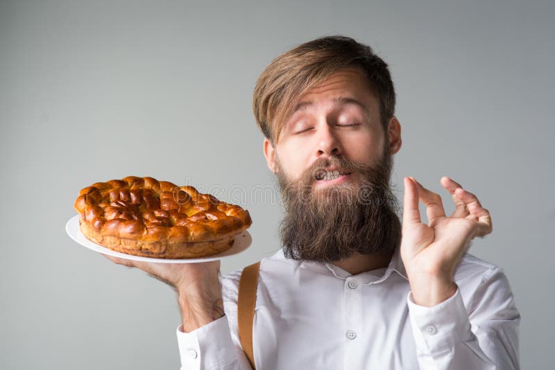 Mens met een baard met een pastei royalty-vrije stock fotografie Mens met een baard met een pastei royalty-vrije stock fotografie