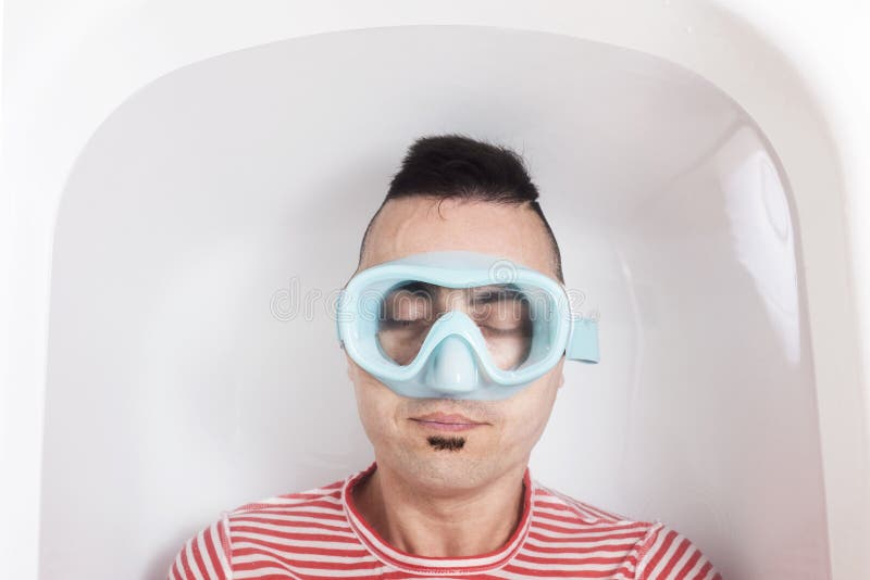 Mens met een het duiken masker in het water van een badkuip royalty-vrije stock afbeelding Mens met een het duiken masker in het water van een badkuip royalty-vrije stock afbeelding