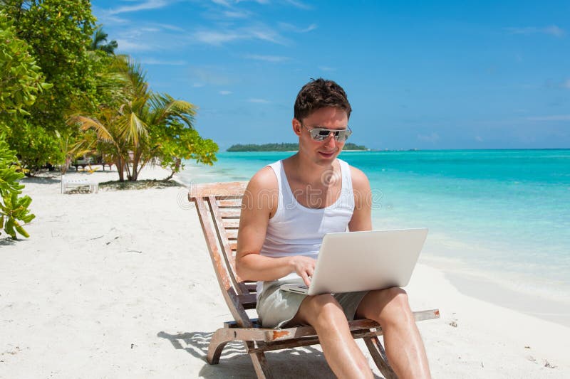 Mens met laptop op het strand royalty-vrije stock afbeelding Mens met laptop op het strand royalty-vrije stock afbeelding