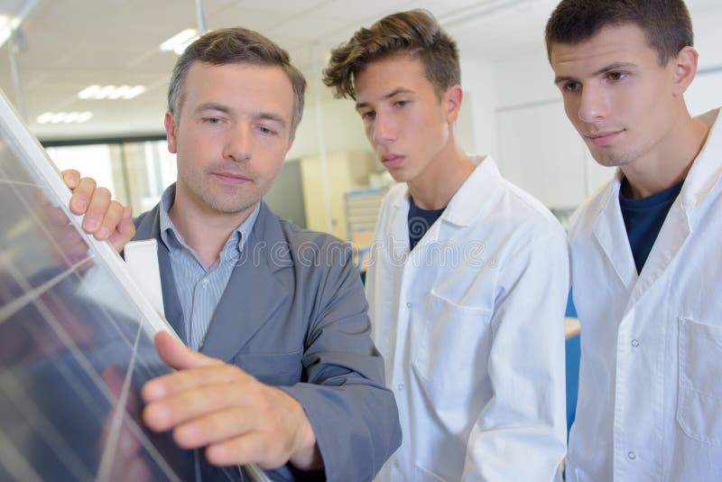 Mens met studenten wat betreft zonnepaneel royalty-vrije stock afbeeldingen Mens met studenten wat betreft zonnepaneel royalty-vrije stock afbeeldingen