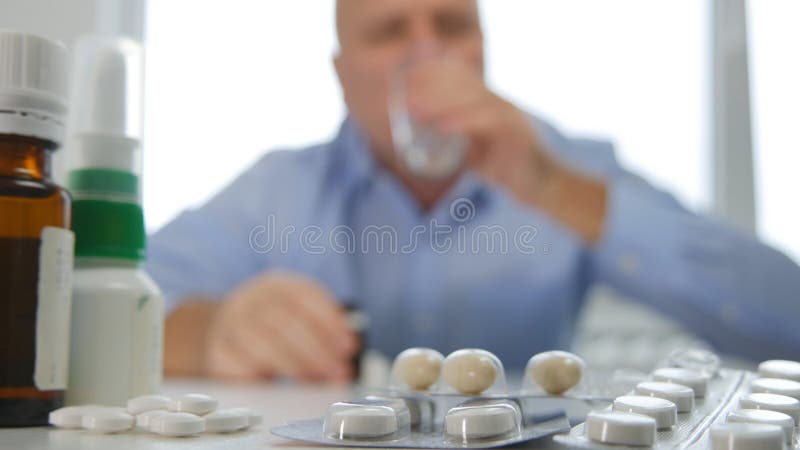 Mens met Vele Pillen op Lijst het Drinken van een Glas met Water stock foto's Mens met Vele Pillen op Lijst het Drinken van een Glas met Water stock foto's
