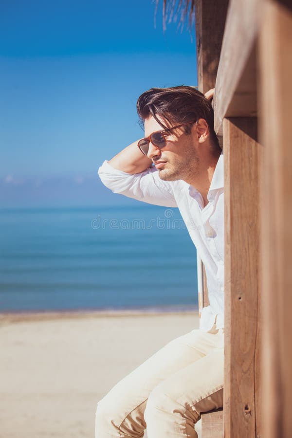 Mens met wit overhemd en zonnebril op strandvakantie die uit eruit zien royalty-vrije stock fotografie Mens met wit overhemd en zonnebril op strandvakantie die uit eruit zien royalty-vrije stock fotografie