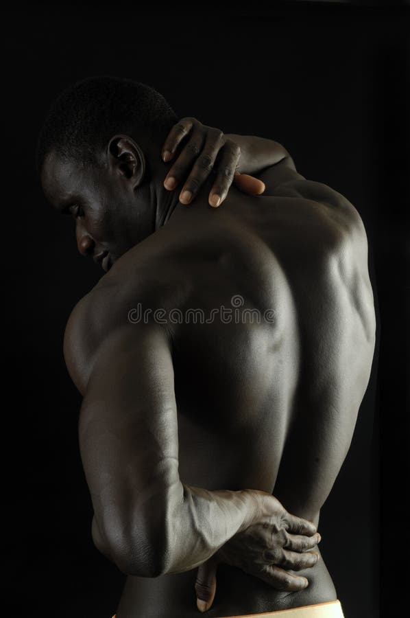 Mens met zijn hand op de rug omdat u pijn, zwarte backg hebt stock fotografie Mens met zijn hand op de rug omdat u pijn, zwarte backg hebt stock fotografie