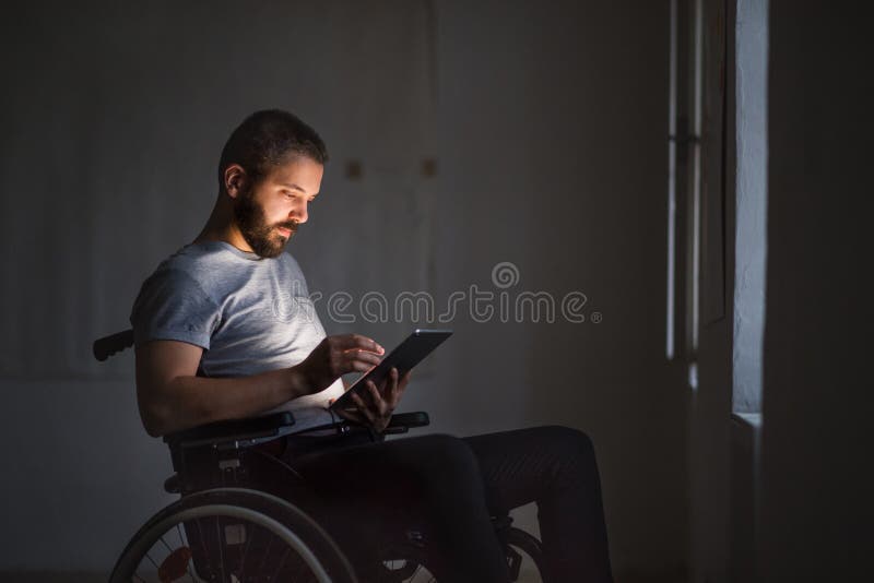 Mens in rolstoel die met tablet werken royalty-vrije stock afbeeldingen Mens in rolstoel die met tablet werken royalty-vrije stock afbeeldingen