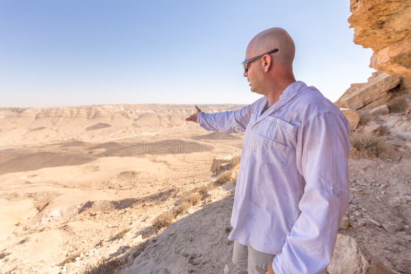 Mens tonen die het landschap van de woestijnkrater moutains richten stock fotografie Mens tonen die het landschap van de woestijnkrater moutains richten stock fotografie
