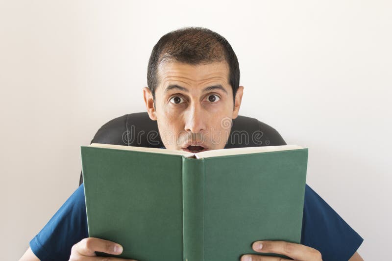 Mens wordt verrast die door wat u leest royalty-vrije stock fotografie Mens wordt verrast die door wat u leest royalty-vrije stock fotografie