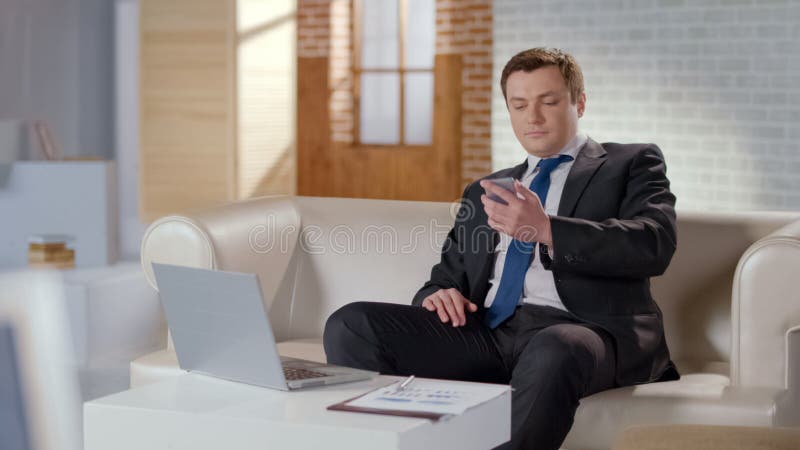 Mensagem da leitura do homem de negócios no telefone celular, resolvendo edições da empresa remotamente fotografia de stock Mensagem da leitura do homem de negócios no telefone celular, resolvendo edições da empresa remotamente fotografia de stock