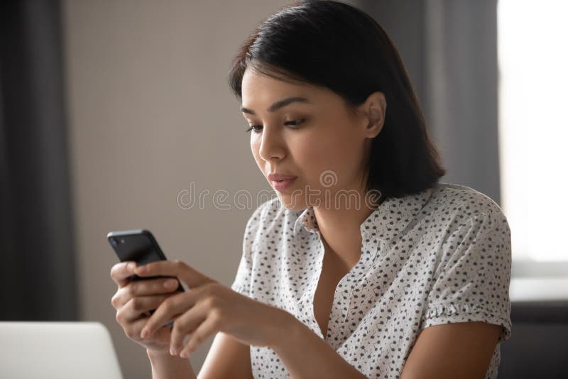 Mensagem de mensagens de texto de uma mulher de negócios japonesa concentrada na ásia no celular