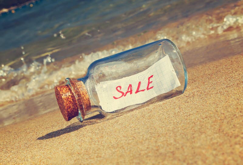 Message in a vintage bottle Sale on beach. Creative marketing and sales concept. Message in a vintage bottle Sale on beach. Creative marketing and sales concept.