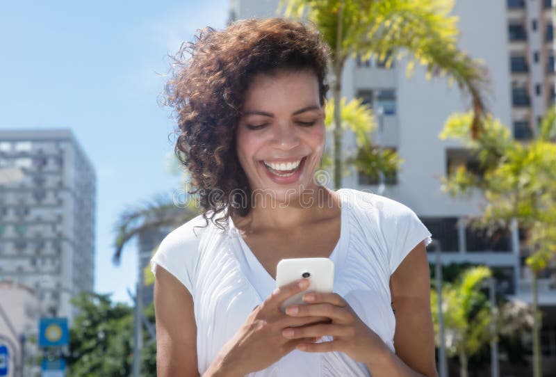 Mensagem latino-americano nova bonita da mulher pelo telefone imagens de stock Mensagem latino-americano nova bonita da mulher pelo telefone imagens de stock