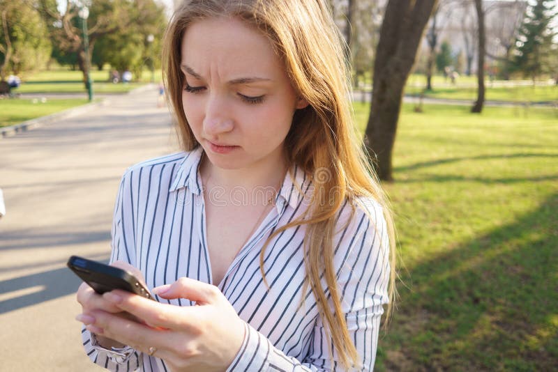 Mensaje que mecanografía de la mujer preocupante joven en su teléfono elegante Gente, r imagenes de archivo Mensaje que mecanografía de la mujer preocupante joven en su teléfono elegante Gente, r imagenes de archivo