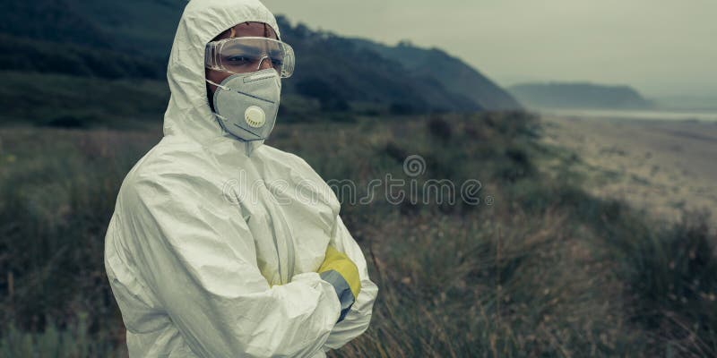 Man in bacteriological protective suit watching to the sea. Man in bacteriological protective suit watching to the sea