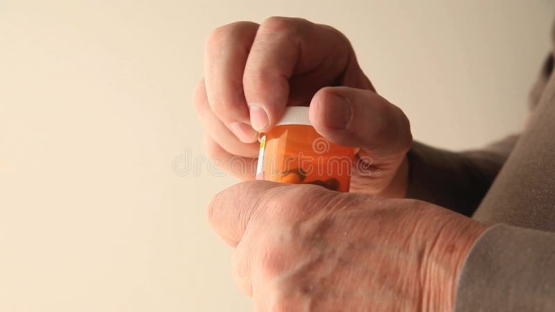 Menschen mit Zittern versuchen, Tabletten zu öffnen