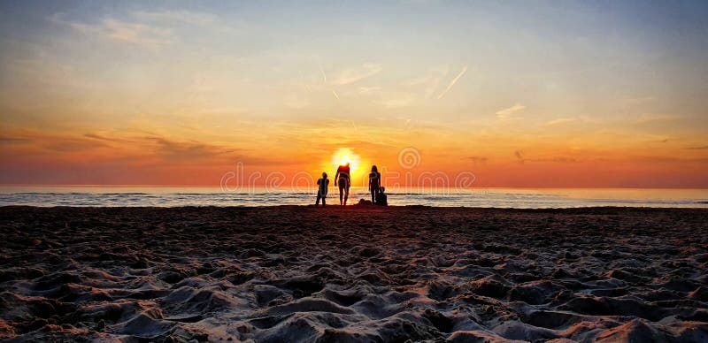 Menschen am Strand bei Sonnenuntergang stockfotos Menschen am Strand bei Sonnenuntergang stockfotos