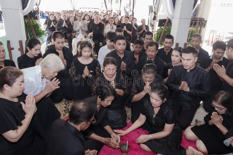 Phatthalung, Thailand- April 05, 2024: People and relatives wear black and pray before the coffin of the deceased at the cremation ceremony. Phatthalung, Thailand- April 05, 2024: People and relatives wear black and pray before the coffin of the deceased at the cremation ceremony