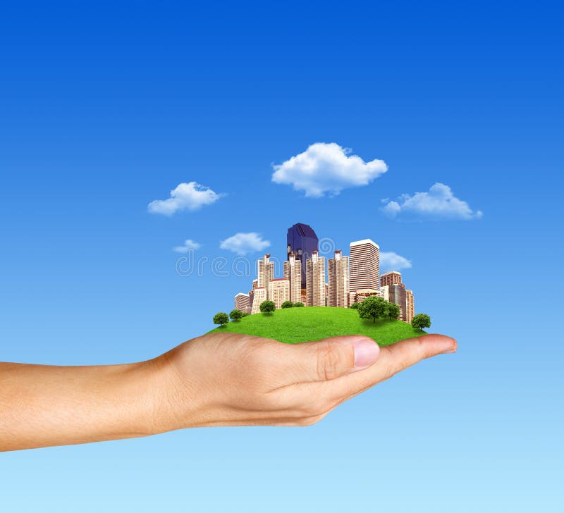 Menschliche Hand des Konzeptes, die eine Stadt auf grünem Gras anhält lizenzfreie abbildung