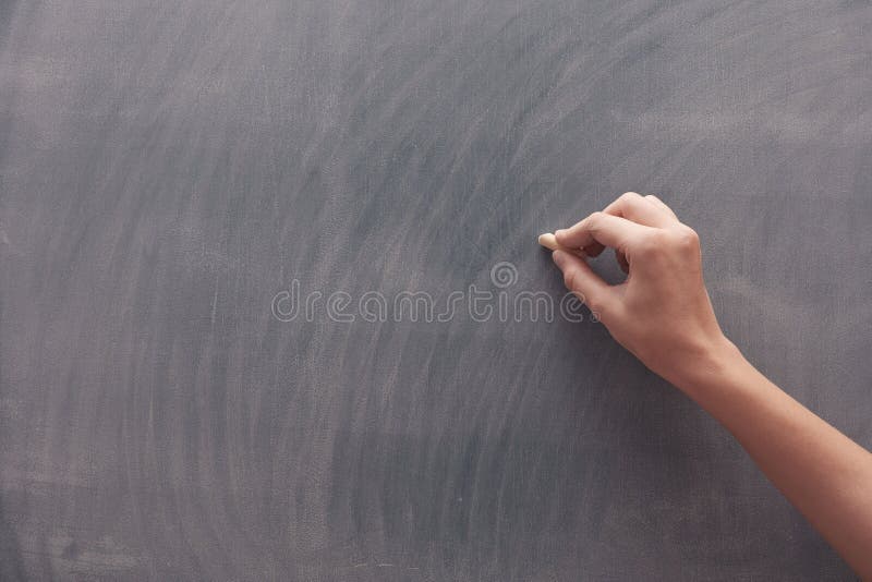 Menschliche Hand mit Kreide an der Tafel stockfotografie