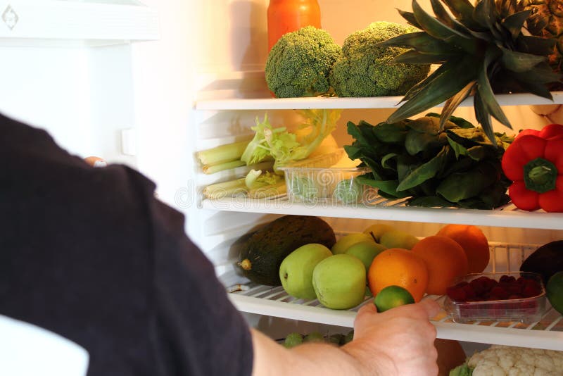 Menselijk Wapen die voor kalkfruit bereiken in Open Ijskasthoogtepunt royalty-vrije stock foto's Menselijk Wapen die voor kalkfruit bereiken in Open Ijskasthoogtepunt royalty-vrije stock foto's