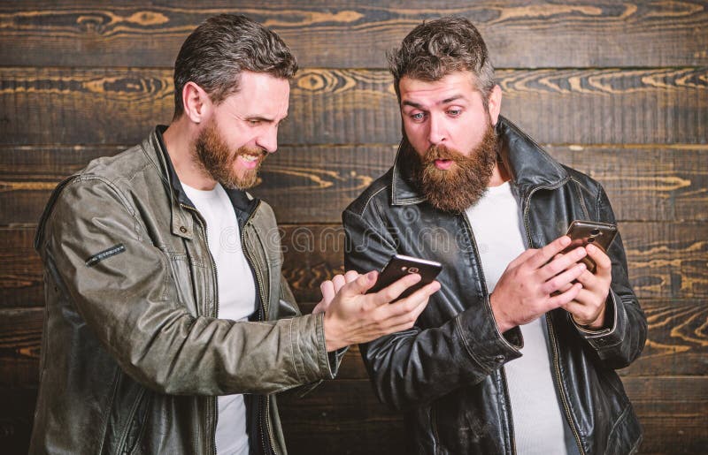 Mensen brutale gebaarde hipster in het modieuze gebruik mobiel Internet van leerjasjes Online zaken Moderne technologie mensen stock fotografie Mensen brutale gebaarde hipster in het modieuze gebruik mobiel Internet van leerjasjes Online zaken Moderne technologie mensen stock fotografie