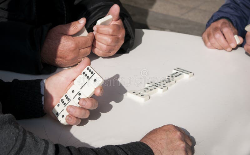 Mature retiree adults playing domino game for leisure. Mature retiree adults playing domino game for leisure