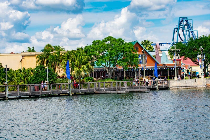 Mensen die op houten brug lopen Weergeven van de kleurrijke haven en achtbaan van Manta Ray in Seaworld op Internationaal Aandrij stock fotografie Mensen die op houten brug lopen Weergeven van de kleurrijke haven en achtbaan van Manta Ray in Seaworld op Internationaal Aandrij stock fotografie