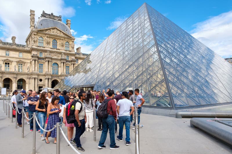 Mensen die zich in lijnwachten bevinden om het Louvremuseum in Parijs in te gaan stock fotografie Mensen die zich in lijnwachten bevinden om het Louvremuseum in Parijs in te gaan stock fotografie