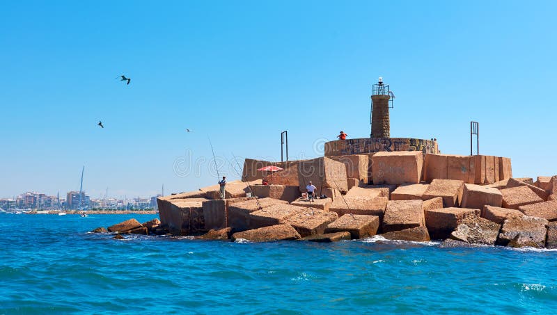 Mensen met hengels op de vuurtoren van Torrevieja spanje stock fotografie Mensen met hengels op de vuurtoren van Torrevieja spanje stock fotografie