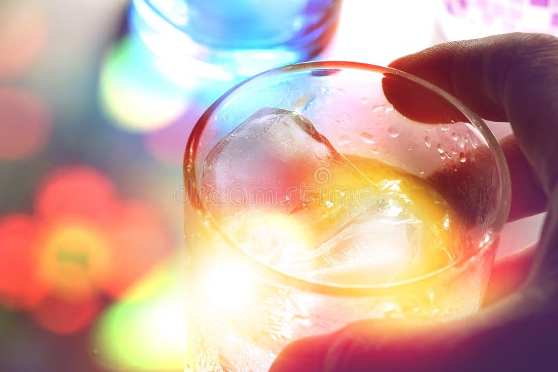 Mensen` s hand die een glas van alcoholdrank houden met ijsblokjes royalty-vrije stock fotografie Mensen` s hand die een glas van alcoholdrank houden met ijsblokjes royalty-vrije stock fotografie