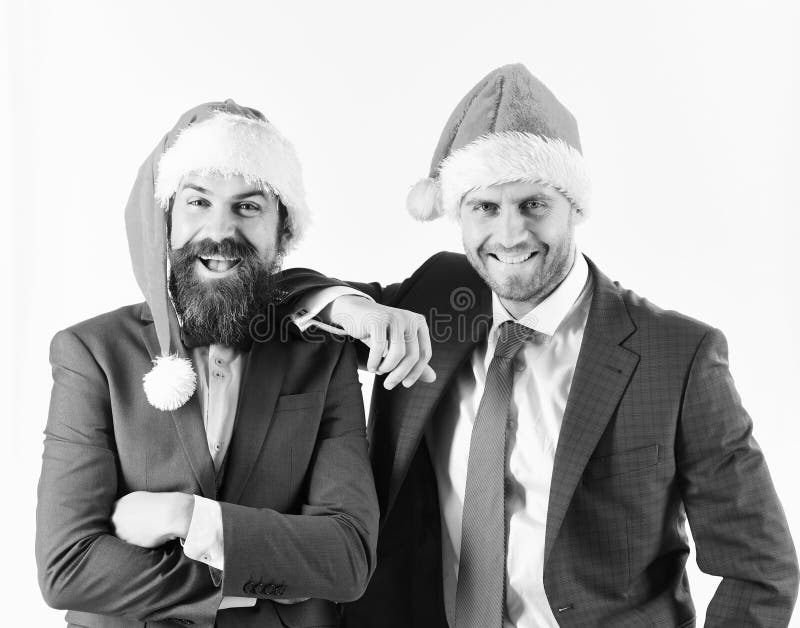 Mensen in slimme kostuums en Kerstmanhoeden op witte achtergrond stock foto Mensen in slimme kostuums en Kerstmanhoeden op witte achtergrond stock foto