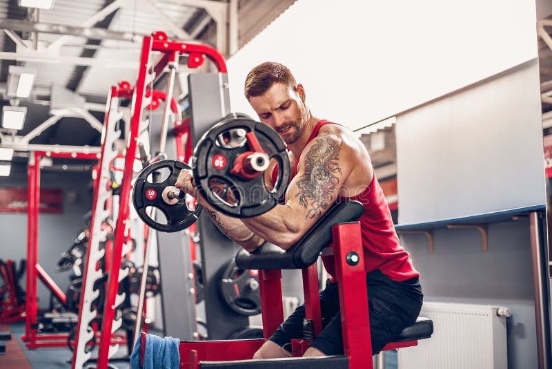 Mensenbodybuilder die de reeks van een barbelloefening doen in een gymnastiek royalty-vrije stock foto Mensenbodybuilder die de reeks van een barbelloefening doen in een gymnastiek royalty-vrije stock foto