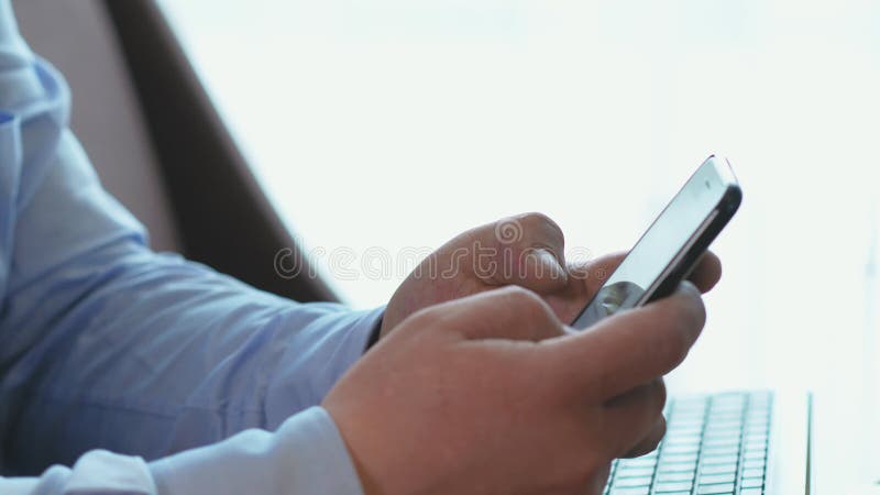 Mensenhand het scrollen op smartphone voor het doorbladeren sociale netwerken in bedrijfsbureau