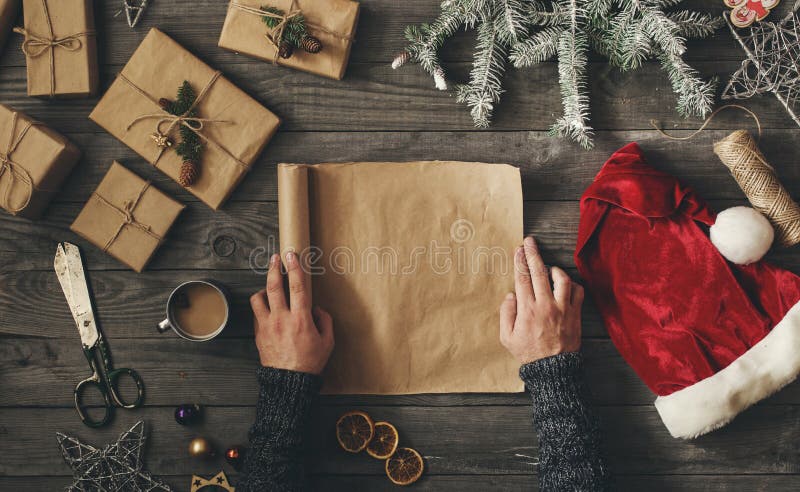 Mensenhanden die leeg blad van document met Kerstmisgift houden stock afbeeldingen Mensenhanden die leeg blad van document met Kerstmisgift houden stock afbeeldingen