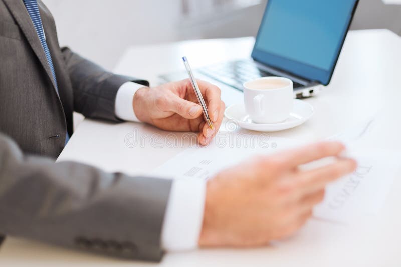 Mensenhanden met contract en pen, koffie en laptop royalty-vrije stock foto Mensenhanden met contract en pen, koffie en laptop royalty-vrije stock foto