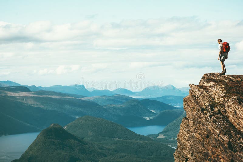 Mensenontdekkingsreiziger die zich op top van de klippen de alleen berg bevinden