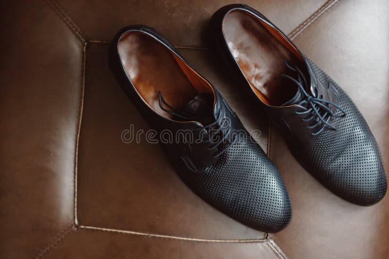 Mensenschoenen op een leerstoel royalty-vrije stock foto's Mensenschoenen op een leerstoel royalty-vrije stock foto's
