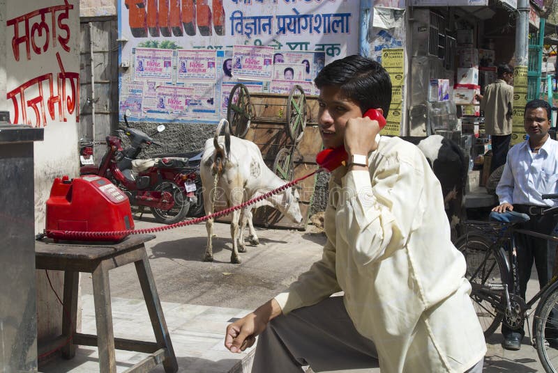 Mensenvraag door de rode telefoon van de straatwinkel, Jodhpur, India royalty-vrije stock foto Mensenvraag door de rode telefoon van de straatwinkel, Jodhpur, India royalty-vrije stock foto