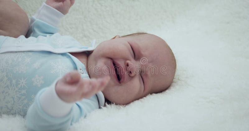 Mensonge pleurant adorable petit bébé sur elle de retour. banque de vidéos